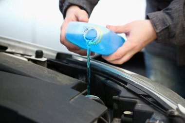 Araba camlarını yıkamak için mavi antifriz koyuyoruz. Antifriz ve araba için damıtılmış su.