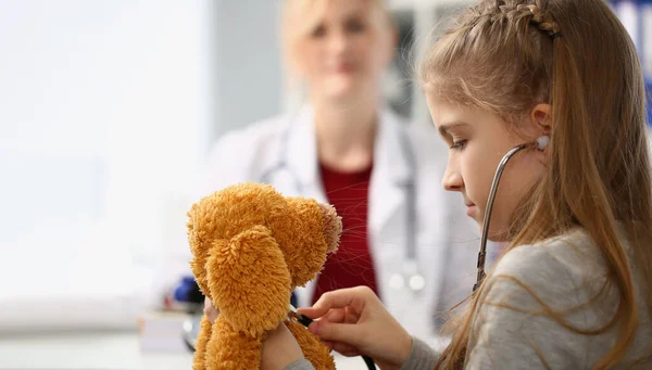 Dziewczyna Dziecko Stetoskopem Słucha Zabawek Tle Siedzi Lekarz Medycyna Dziecięca — Zdjęcie stockowe
