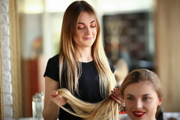Kobieta Fryzjerka Wygląda Długie Włosy Blond Salonie Piękności Przygotowanie Włosów — Zdjęcie stockowe