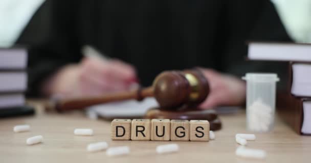 Λευκά Χάπια Και Λέξη Ναρκωτικά Ξύλινους Κύβους Κοντά Δικαστή Gavel — Αρχείο Βίντεο