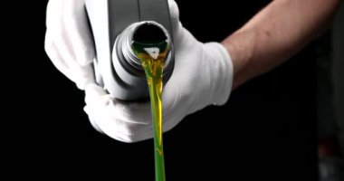 Usta tamirci araba motoruna makine yağı döküyor. 4K film yavaş çekimde kapanıyor. Araba bakım motoru yağ değişimi kavramı