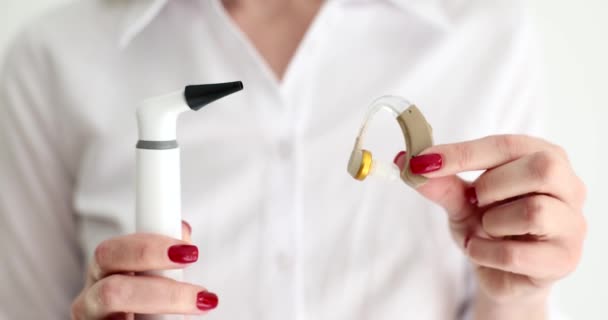 耳鼻咽喉科医は聴診器を保持し 補聴器を閉じる4K映画スローモーション 難聴の診断と治療の概念 — ストック動画