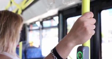 Kadın toplu taşımacılıkta tırabzanlara tutunuyor. Metro vagonunda ya da otobüste elinde kalem tutan kız.