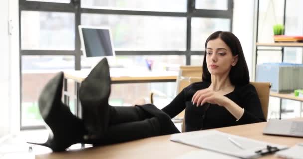 沉着而又梦幻般的年轻女商人休息一下 完成工作 把脚放在桌子上 经理在工作中不会感到压力 — 图库视频影像
