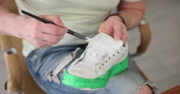 车间里有人用白漆画皮鞋 运动鞋修理 — 图库视频影像