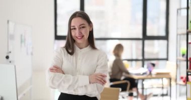 Ofiste poz veren ve gülümseyen kendine güvenen bir iş kadını. Öğrenci stajyer yeni fırsatlar ve planlama hedefi hakkında düşünüyor.