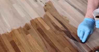 Ahşap yüzeyi kaplayan koruyucu eldivenli marangozların elleri. Marangozluk ve marangozluk kavramı