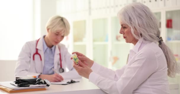 医生在诊所给老年妇女吃药 长者头痛药丸 — 图库视频影像