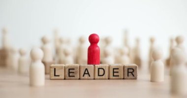 Birbirinin aynısı bir sürü tahta adam ve kırmızı bir adamın heykeli ve metin lideri. Özel lider ve başarılı bir kariyer.