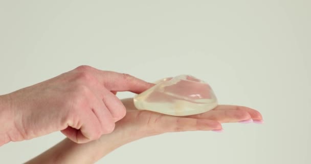 Kobieta Trzyma Implant Piersi Wskazuje Palcem Zbliżenie Chirurgia Plastyczna Powiększenie — Wideo stockowe