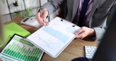 Ofis masasında iki çalışanın buluşması verilerle birlikte çizelgelerde çalışıyor. Grafik çizelgesi ve iş stratejisi ile takım çalışması