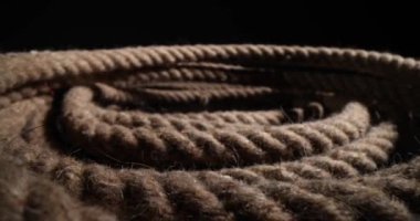 Denizcilik halatı, siyah arkaplanda spiral şeklinde katlanmış. İplik ve liflerin detaylarını gösteren kalın, ağır görev halatının kapatılması