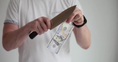 Adam keskin bıçaklı banknot kesiyor. Yakın çekim 4K film yavaş çekim. İflas ve ekonomik kriz kavramı