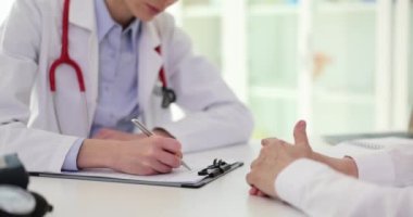 Steteskoplu odaklanmış doktor olgun hastaların tedavi planlarını panoya yazıyor. Klinikte ağır çekimde uzman bir kadınla randevusu var.