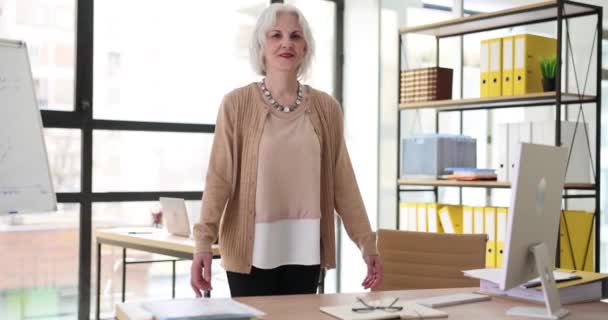 一个积极成熟的女商人在公司的办公室里靠在桌子上慢动作 有信心的高级女上司在工作场所 老年人的职业 — 图库视频影像