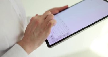 Kadın ofisteki tablet bilgisayar dokunmatik ekranına mesaj yazar. İş görevleri için dijital iletişim teknolojisi. İş yerinde aygıtı olan bir çalışan