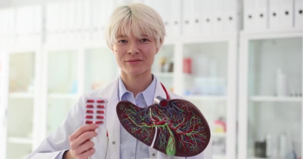Médico Rubia Positiva Sostiene Píldoras Ampolla Mano Cerca Modelo Hígado — Vídeo de stock