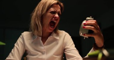 Kadın yönetici zamanı kontrol ediyor. Saçı eliyle tutuyor ve çığlık atıyor. Sarışın kadın fırtına sırasında ofiste çalar saate bakmaktan korkar.