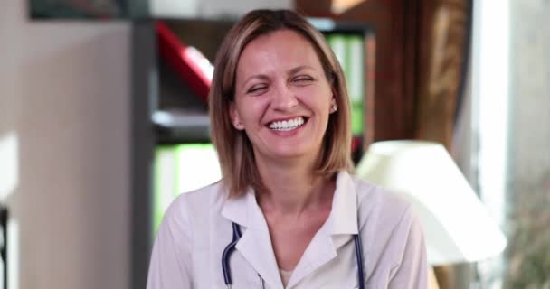积极的女医生与听诊器谈论医疗保健在临床上的重要性 穿着军服的快乐女人露出笑脸慢动作 — 图库视频影像