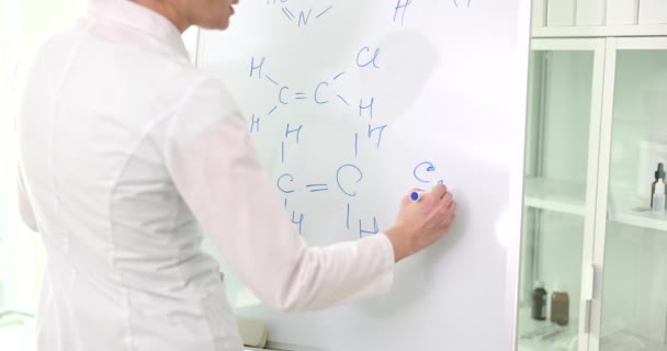 Επιστήμονας Γράφει Μοριακούς Τύπους Χημικών Ενώσεων Λευκό Πίνακα Βοηθός Εξετάζει — Αρχείο Βίντεο