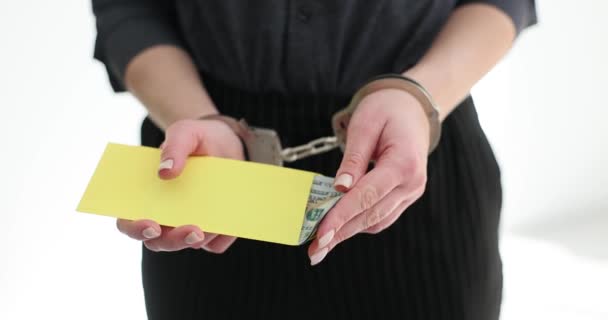 戴手铐的妇女拿着黄色的信封 把钞票藏在警察局里 因贿赂及贪污而被捕的刑事人士行动缓慢 — 图库视频影像