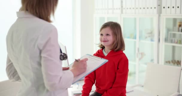 Lekarka Podkładką Bada Dziewczynkę Podczas Wizyty Lekkim Szpitalu Nowoczesna Opieka — Wideo stockowe