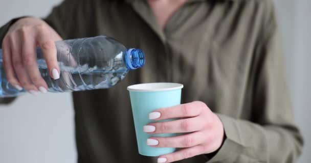Mujer Sostiene Una Botella Plástico Con Agua Una Taza Papel — Vídeos de Stock