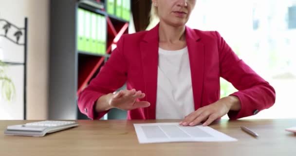 烦躁的女人拒绝签署荒谬的合同 并把文件扔掉 身穿粉色夹克的女性伴侣在办公室慢动作中坐在木制桌旁 — 图库视频影像