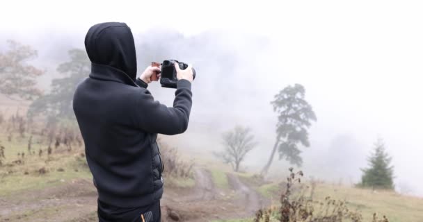 Mann Mit Kamera Filmt Schlechtwettertagen Dichten Nebel Waldschlucht Videograf Schwarzer — Stockvideo