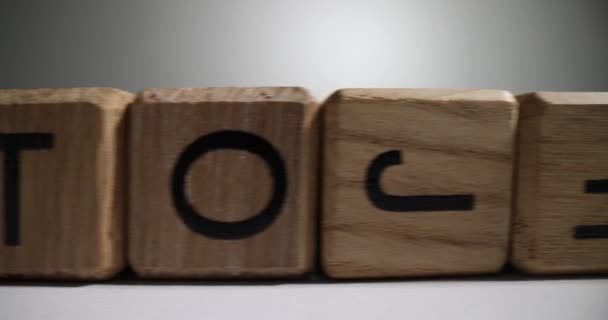 木製のキューブで作られたラインは 英語のアルファベットの文字で Abc文字が正しくない逆ブロックが間違った順序で白い表面に立つ — ストック動画