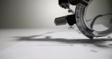 Görsel keskinliği ölçmek için optometrik gözlük kağıt Snellen grafiğinde bulunur. Görme yeteneğini kontrol etmek için tıbbi ekipman doktor muayenehanesinde hastayı bekliyor.