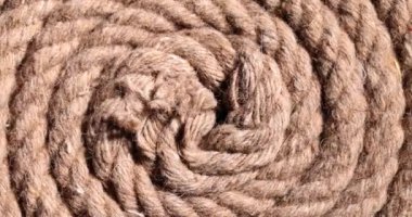 Pamuktan yapılmış kalın, sarmal bir ip yerde yatıyor. Eskimiş kenevirden yapılmış eski bir yelkenli ipi. İp parlak ışıkta ağırlık kaldırmak için tasarlandı