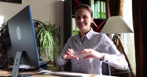 Lächelnde Frau Macht Herzgeste Wenn Sie Schreibtisch Mit Computer Sitzt — Stockvideo
