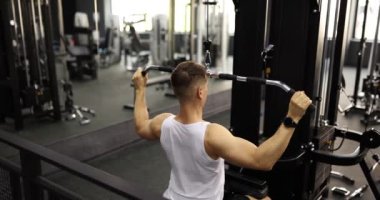 Spor simülatöründe antrenman yapan ve spor salonu 4K filminde ağır çekimde ağırlık kaldıran adam. Kol gücü kavramı geliştirir.