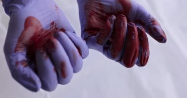 Kauçuk koruyucu eldivenli cerrahın elini sıkarak 4K 'lık yakın çekim filmi ağır çekimde. Ölümcül sonuç kavramına sahip başarısız cerrahi operasyonlar