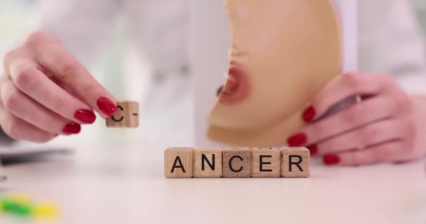 肿瘤学家持有女性乳房解剖模型 并在临床特写4K片慢动作中写下癌症字 预防和治疗肿瘤疾病的概念 — 图库视频影像