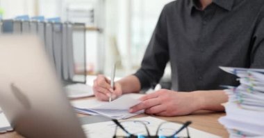 Müdür, mali belgeleri istatistiklerle okur, düzeltmeler yapar ve verileri karşılaştırır. Makaleyi değiştirmek için özenli bir kadın.