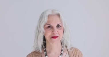 Kameraya bakan gülümseyen yaşlı kadın portresi. Kırışıklıkları olan yaşlı kadının neşeli duyguları.