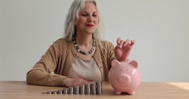 Starsza Kobieta Wkłada Monety Skarbonki Oszczędności Emerytalne Ubezpieczenie — Wideo stockowe