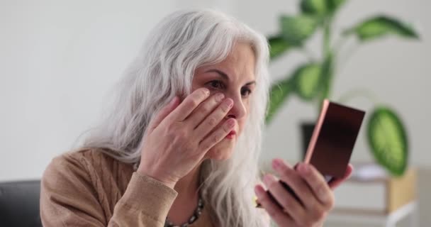 白发苍苍的老妇人在家里的镜子里看着皱纹和眼皮底下的瘀伤 女性皮肤结构 — 图库视频影像