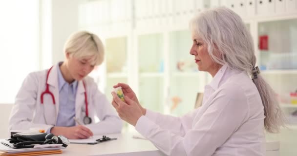 Terapeut Ger Läkemedelsburk Till Äldre Kvinnliga Patienter Kliniken Cardio Piller — Stockvideo