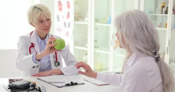 Lekarz Kosmetolog Daje Zielone Jabłko Pacjentce Klinice Zdrowe Odżywianie Emerytury — Wideo stockowe