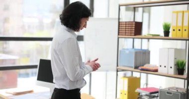 Gergin düşünen düşünceli işadamı ofiste dolaşıyor. Stajyer işte zor kararlar verir ve adamı strese sokar.
