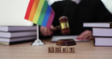 LGBT hakları, hukuk ve Yargıç Tokmak 'ın arka planında LGBTQ yazılı tahta bloklar. Eşcinsel çiftleri kabul etmek hukuk ve adaletin sembolüdür.