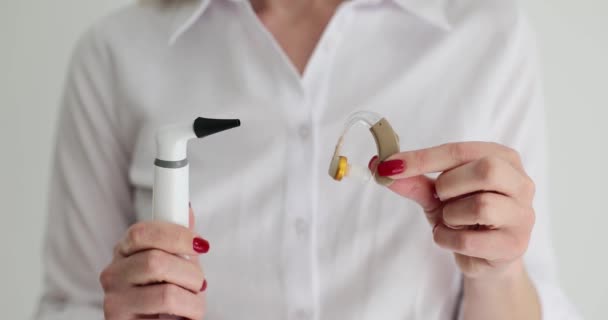 耳鼻咽喉科医は聴診器と補聴器を保持しています 耳疾患の聴覚障害と治療 — ストック動画