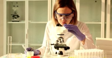 Bilim adamı biyoloğu araştırma laboratuarındaki mikroskoba bakıyor. Bilim eğitimi ve kimyasal araştırma