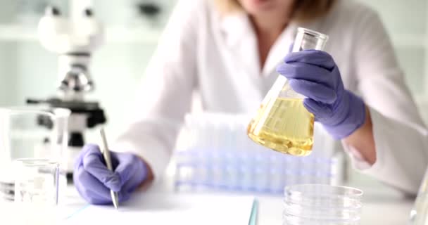 과학자들은 플라스크에서 노란색 액체의 실험실 실험을 실험실에서의 — 비디오