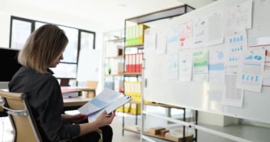 SEO analist pazarlamacısı, mali belgeleri ofisteki bir kurulda hesaplıyor. Satış bölümünün istatistiksel raporu