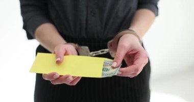 Elleri kelepçeli kadın, elinde dolarlarla zarf tutuyor. Seo rüşvet ve yolsuzluktan tutuklandı