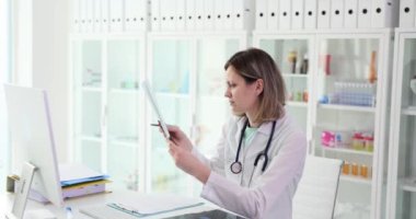 İyimser tıbbi pratisyen hasta kemiklerinin röntgenlerini inceliyor. Sıhhiye, ofiste oturan tıbbi röntgen incelemesini yapıyor.